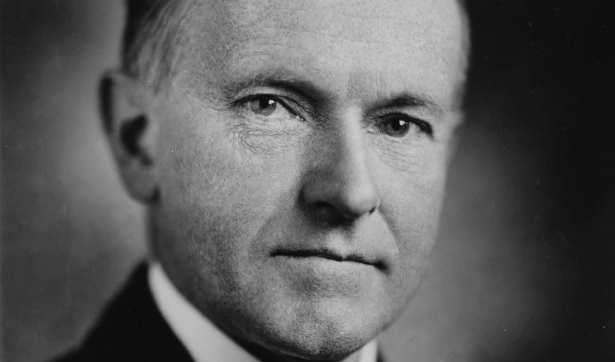 Calvin Coolidge in his 1924 portrait photograph, in a dark suit and tie.