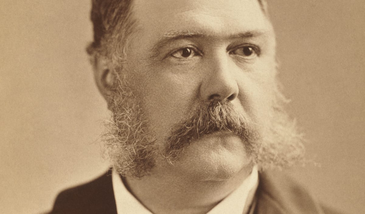 Chester A. Arthur in a photographic portrait, with full side whiskers and a dark coat.