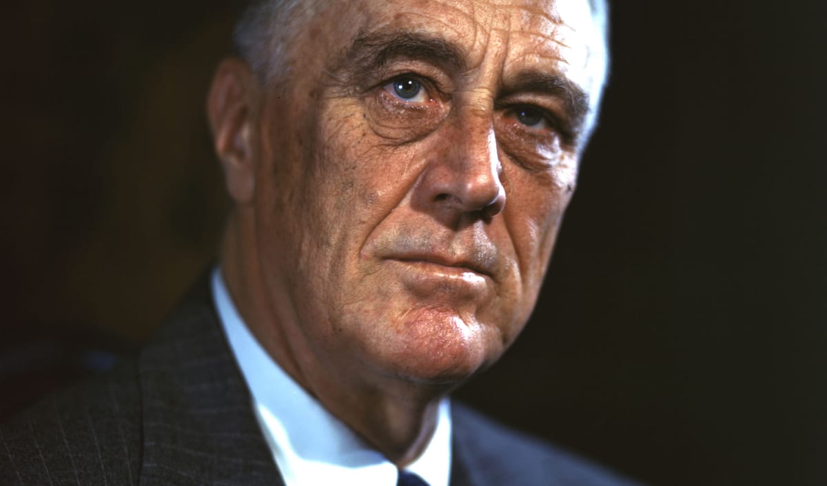 Franklin D. Roosevelt in a 1944 color campaign portrait, in a dark suit and tie.