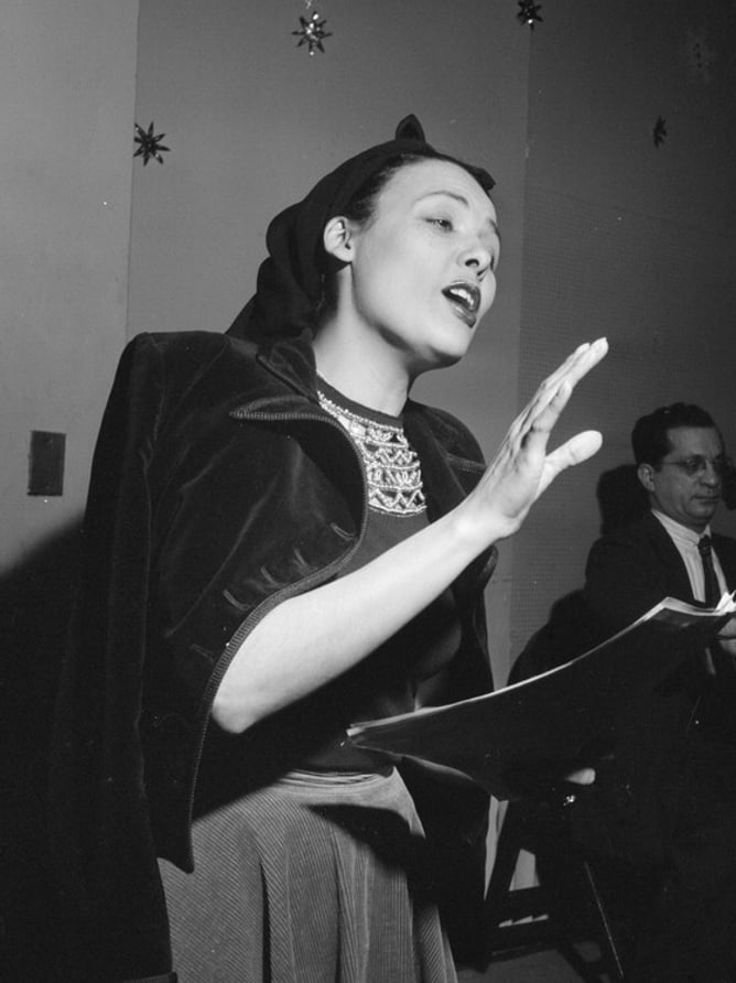 Lena Horne singing at a New York club between 1946 and 1948, photographed by William P. Gottlieb, in black and white.