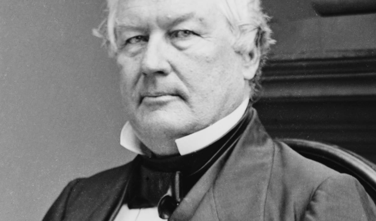 Millard Fillmore in an early photographic portrait, seated in a dark coat with a white collar.