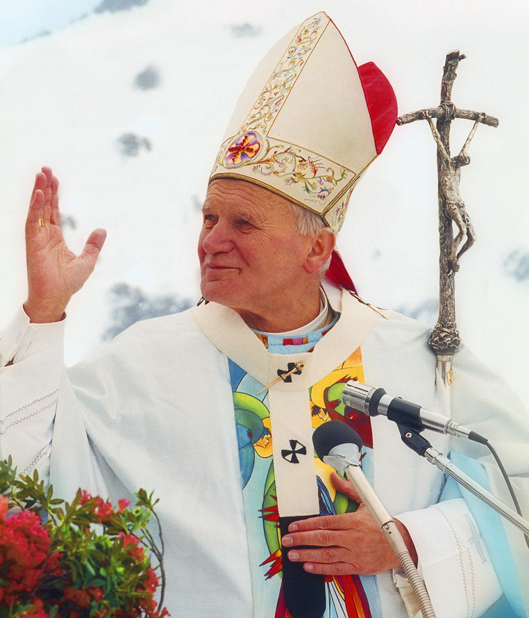 Pope John Paul II photographed in 1988, in white papal vestments, waving to a crowd.