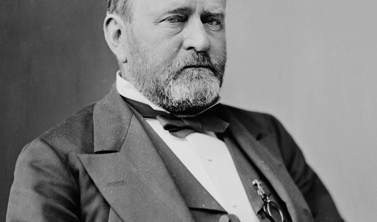 Ulysses S. Grant in a photographic portrait from the 1870s, bearded and in a dark coat.