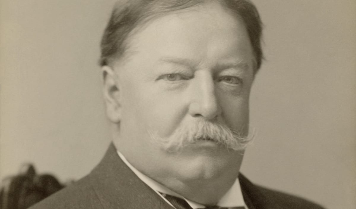 William Howard Taft in a photographic portrait, with a full moustache and a dark coat.